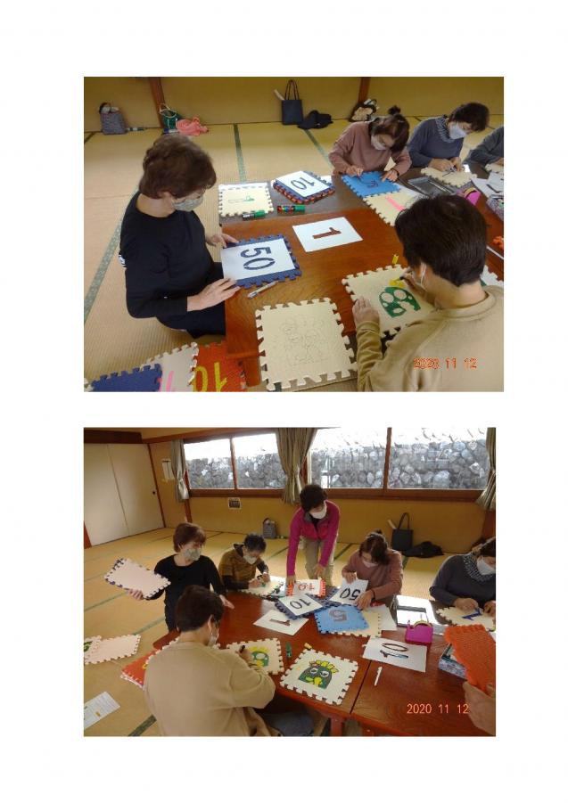 メンバーらがマットに数字やマスコットを描いている様子の写真