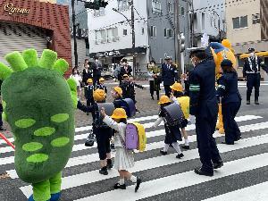 手を挙げて横断歩道を渡る子供達