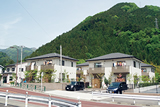 緑の山がバックに建つきれいに整理された町営若者住宅の写真