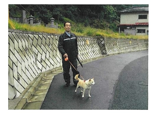 犬と一緒に散歩をしている男性の写真