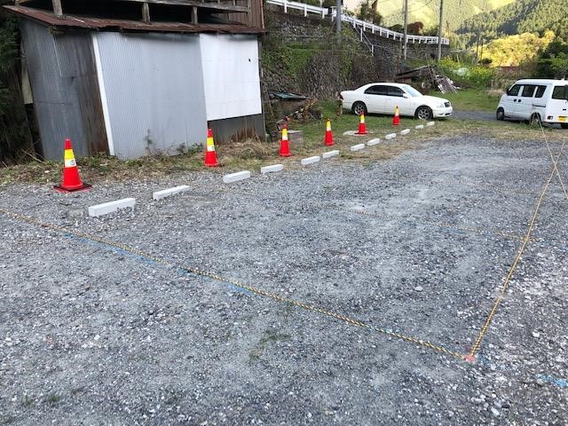 空き地に車止めと紐でラインを引き設置した駐車場の写真